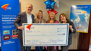 A woman holding a large check with three other people