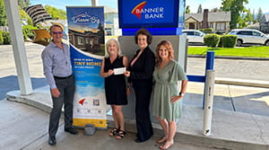 A woman holding a check next to three other people.