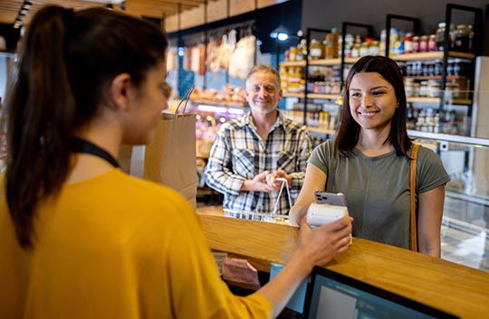 Person paying at market with handheld device