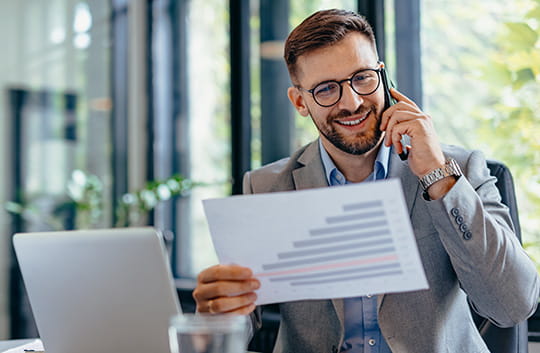 Person on phone looking at paper in office