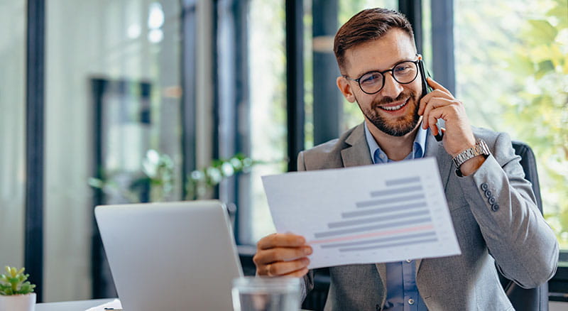 Person on phone looking at paper in office