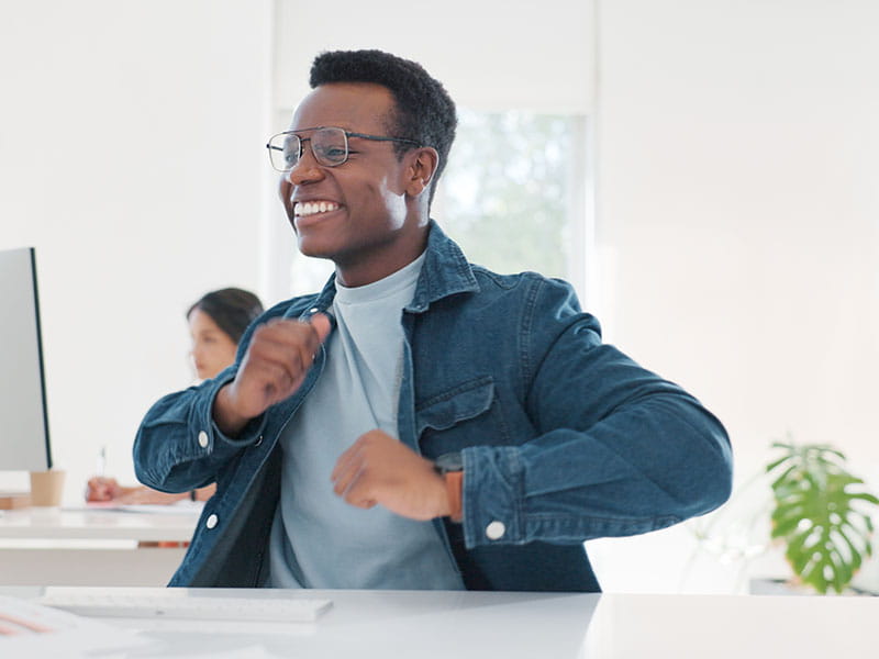 Person celebrating at computer in office
