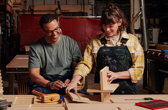 Two people working in a woodshop
