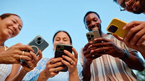 Four people on their smart phones