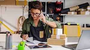 Person on the phone and looking at papers in a work space