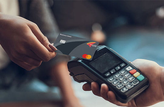 Businesswoman uses Banner Bank business debit card at point-of-sale terminal