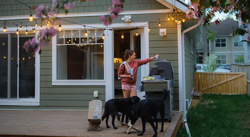 Person on a backyard porch using the grill in the spring