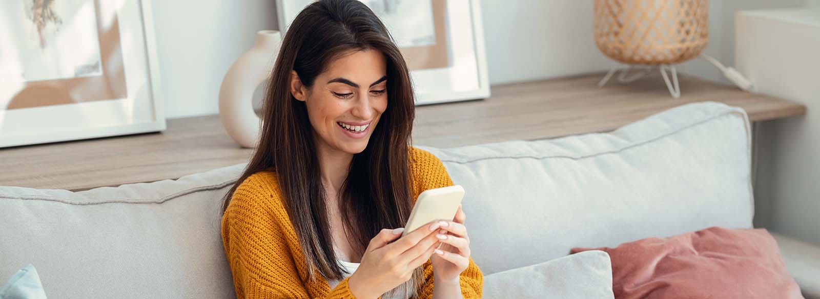 Woman sitting on a couch looking at a phone