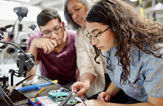 Professor helps college engineering students with electrical project