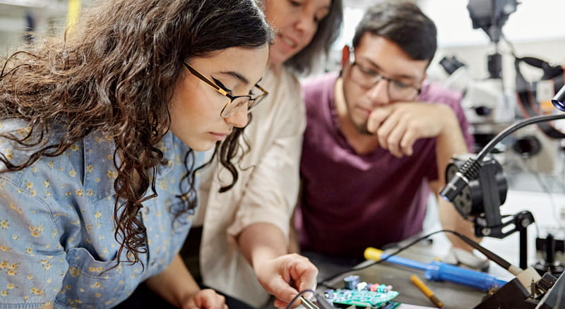 Professor helps college engineering students with electrical project