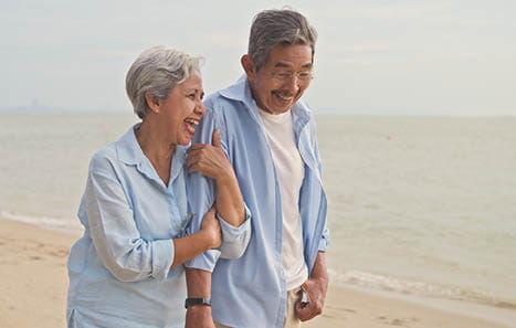 Older couple walking on a beach