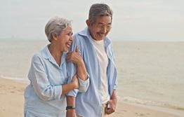Older couple walking on a beach
