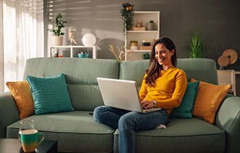 woman sitting on a couch with her computer
