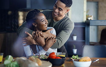 man and woman standing in their kitchen