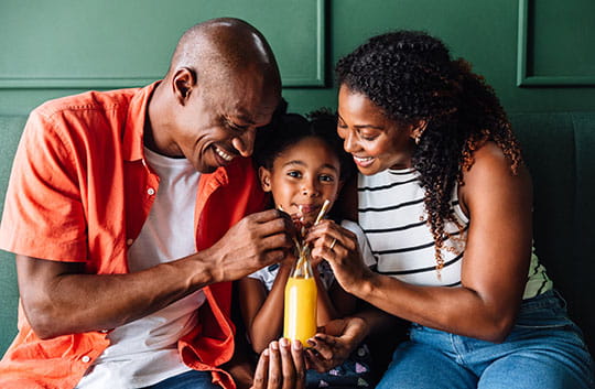 Parents hugging their daughter