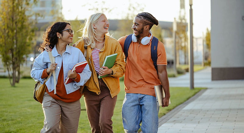 Three students walk on campus