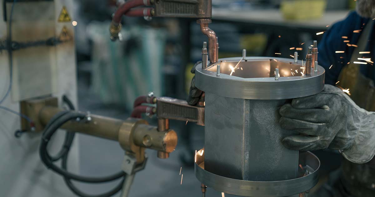 PCT employee working with metal in factory