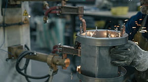 PCT employee working with metal in factory