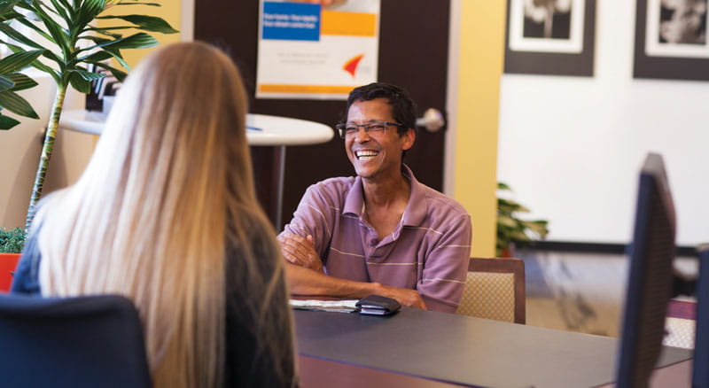 A Banner Bank employee opens a new account for a man who has come in to the branch.