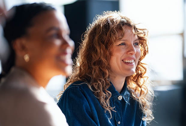 Two people smiling in bright office