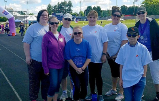 Banner employees standing outside on a track at a relay for life event