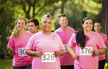 Diver group of women all wearing pink shirts with race numbers pined to their shirts