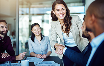 Diverse group of business people woman standing shaking hands with african american male