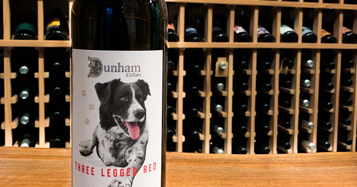 Dunham Cellars wine bottle with wine racks in the background