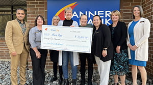 A woman holding a check with six other people