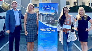 A woman holding a check next to three other people.