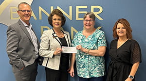 Two women holding a check and a man and woman next to them.