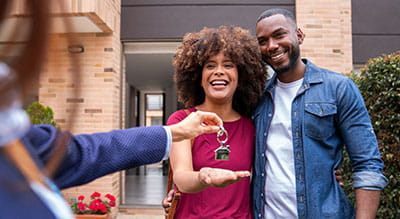Two people being handed keys to a new home