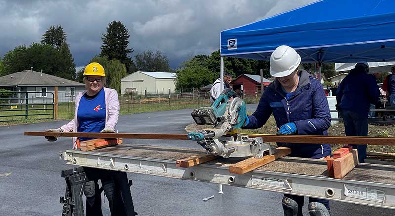 Banner Bank employees cutting wood at home building event