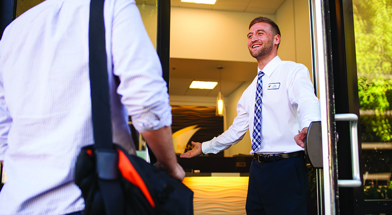 Banner Bank male employee welcoming in a client in to a bank branch