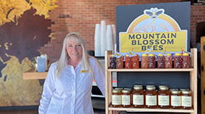 Mountain Blossom Bees owner posing with honey