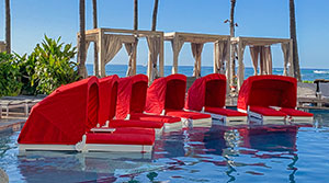 Red Soldura Daybed in pool, made by Outdoor Design Studio