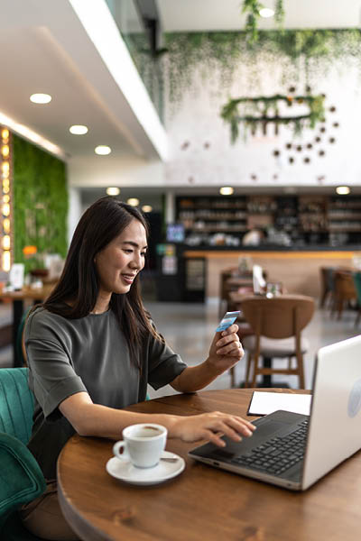 woman at her computer looking at her credit card
