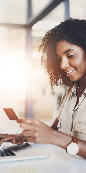 woman sitting at her computer with her credit card