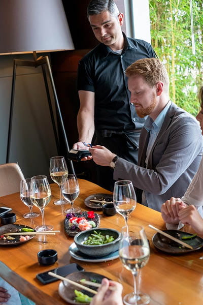 business man paying at restaurant with tap to pay