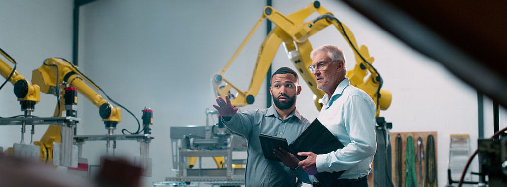 Two people pointing with business equipment in office space
