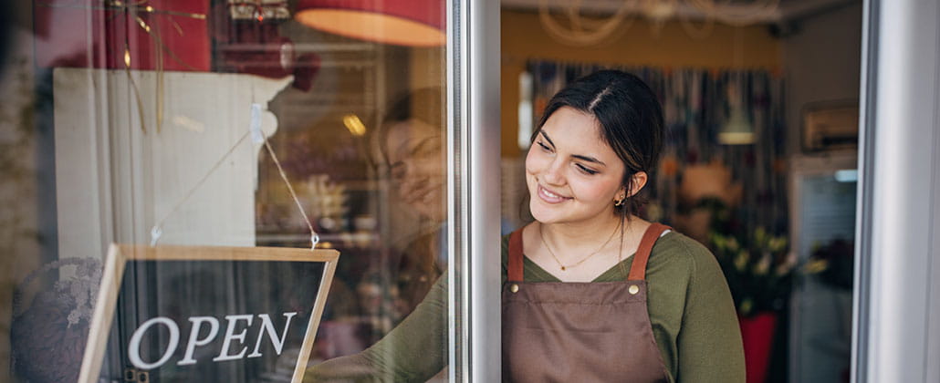 Person in door switching a shop sign to open