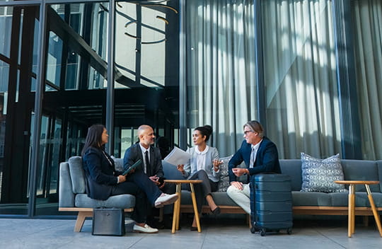 Colleagues sitting at a table in a large lobby