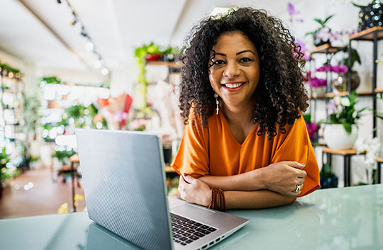 Person in floral shop with laptop