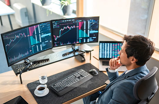 Person in office looking at multiple computers