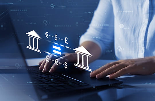 Person on computer with bank and foreign currency symbols