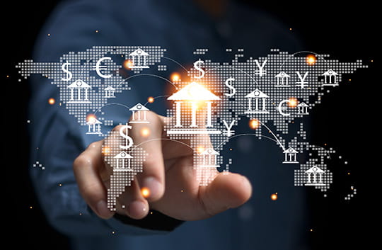 Person pointing at bank icon over a globe icon and currency symbols