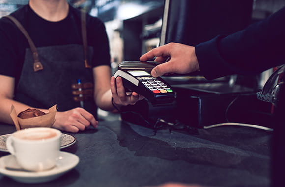 Person paying with phone at merchant card reader