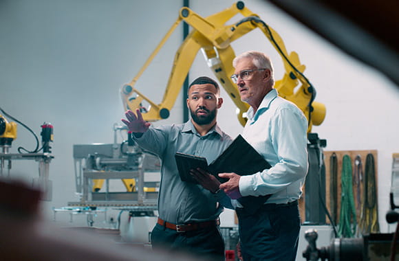 Two people pointing with business equipment in office space