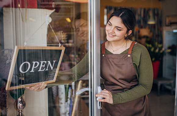 Person in door switching a shop sign to open