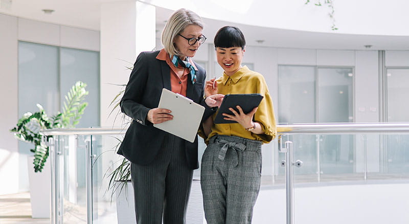 Two colleagues looking at a tablet in office space